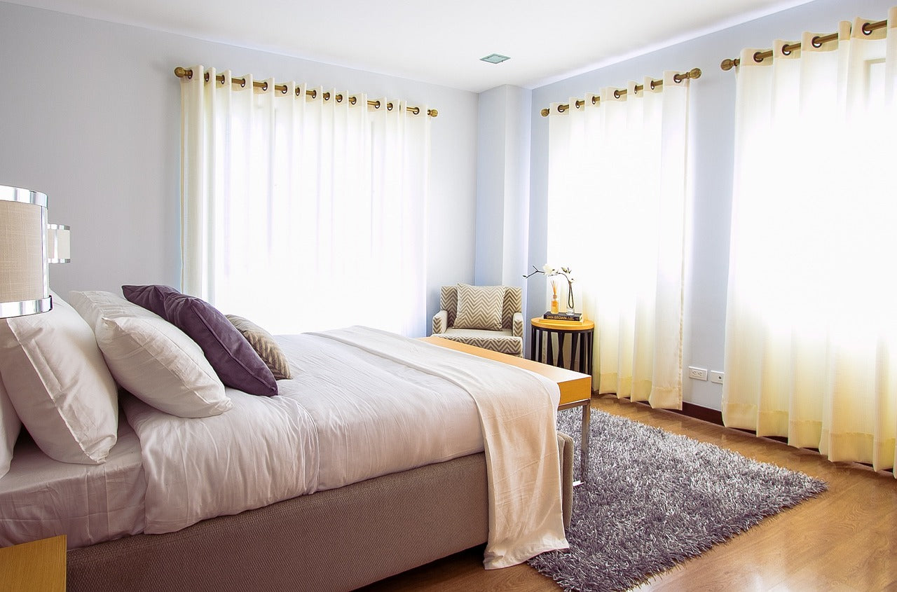 bedroom with three sets of long curtains